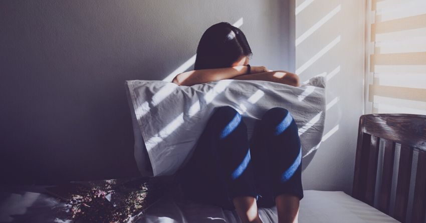woman sitting in bed, depression, sadness