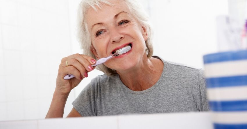 senior woman brushing teeth