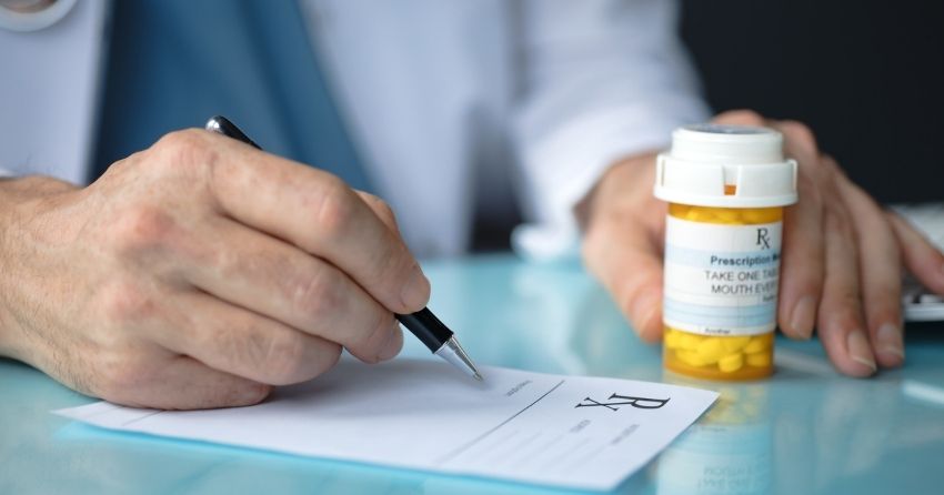 a common class of medications known as anti-cholinergic drugs are linked to an increased risk of mild cognitive impairment; doctor writing prescription for medication