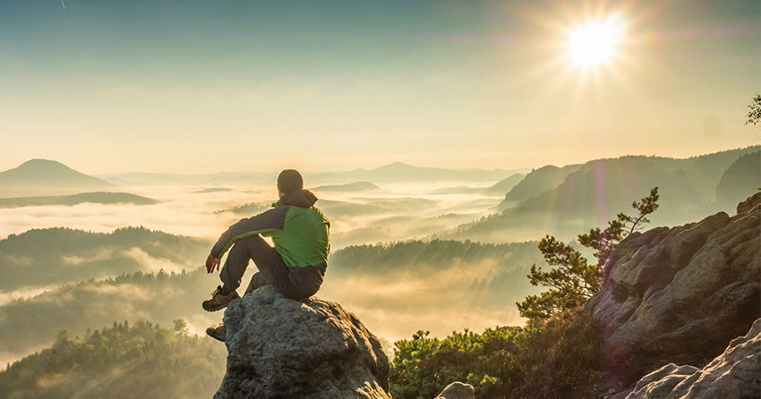 man sitting on top of a mountain