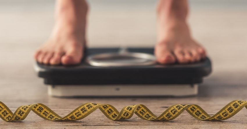 the drug semaglutide has been found to significantly reduce obesity; adult standing on scale