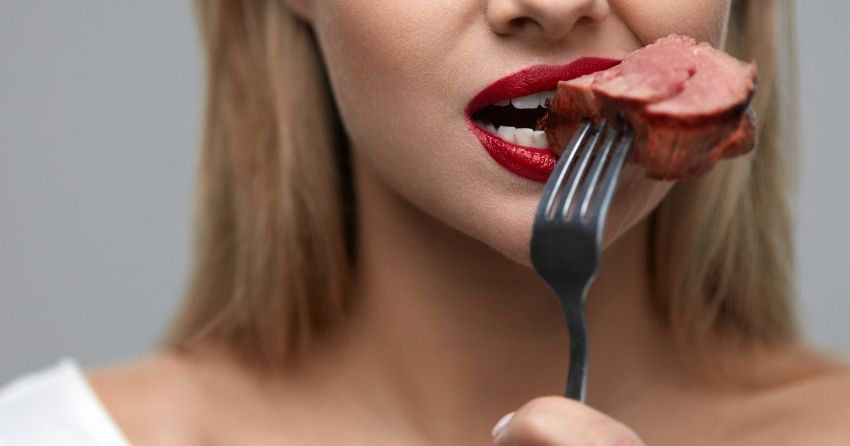 woman eating meat; how what type of meat we eat impacts cognition